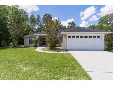 Charming home boasts a well-manicured lawn, inviting walkway, and attached two-car garage at 5460 Sw 103Rd Street Rd, Ocala, FL 34476