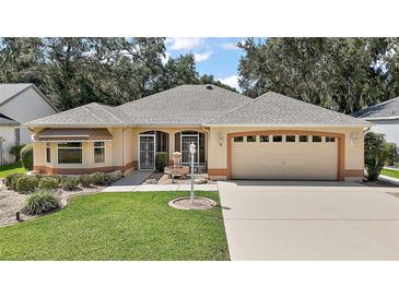 Charming single-story home with a well-manicured lawn and a two-car attached garage at 1512 Cervantes Pl, Lady Lake, FL 32159