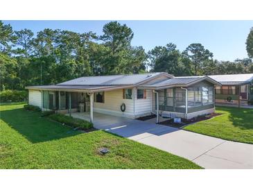 Charming single-story home with a metal roof, screened porch, and a well-maintained front lawn at 1855 Stacey Dr, Mount Dora, FL 32757