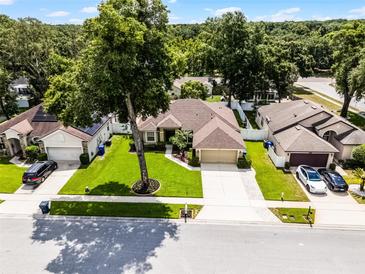 Aerial view of home with well-manicured lawn, mature trees, and a long driveway leading to the attached garage at 2389 Grand Poplar St, Ocoee, FL 34761