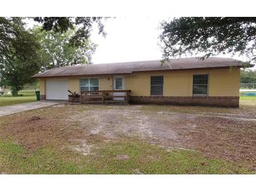 Charming one-story home with a well-manicured lawn and attached garage at 302 W Rose Ln, Lady Lake, FL 32159