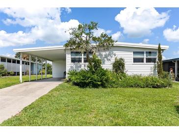 Charming single-story home with a well-maintained lawn and covered parking at 717 W Coach N Four Dr, Leesburg, FL 34748