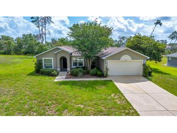 Charming single-story home boasts a manicured lawn, mature landscaping, and an attached two-car garage at 10331 Sw 45Th Ave, Ocala, FL 34476