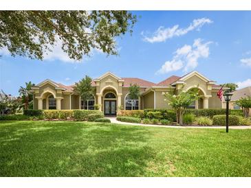 Charming traditional home with a manicured lawn, lush landscaping, and an inviting facade at 1043 Juliette Blvd, Mount Dora, FL 32757