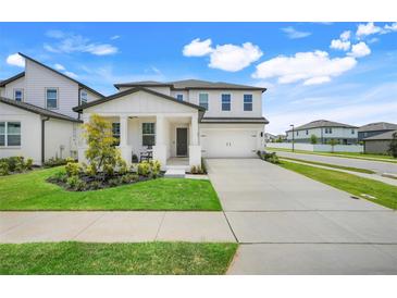 Charming two-story home featuring a covered front porch and a well-manicured lawn at 2161 Gold Dust Dr, Minneola, FL 34715