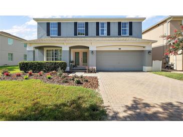 Charming home featuring a two-car garage and a beautifully landscaped front yard at 621 Lost Grove Cir, Winter Garden, FL 34787