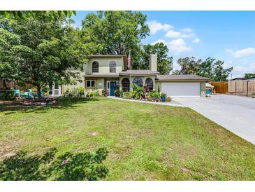 Charming two-story home featuring mature trees, landscaped yard, and attached two car garage at 628 Drew Ave, Clermont, FL 34711