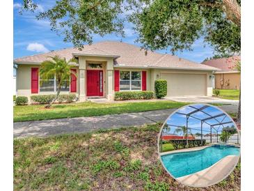 Charming single-story home featuring a red front door, red shutters, well-manicured landscaping, and a beautiful pool at 1216 Cheshire St, Groveland, FL 34736