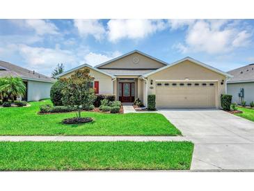 Charming single-story home featuring a manicured lawn and a two-car garage at 26653 Otter Creek Ln, Leesburg, FL 34748