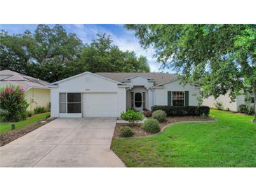 Charming single-story home with a well-maintained lawn and landscaped garden at 32942 Rambling Oaks Ct, Leesburg, FL 34748