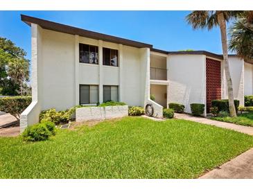 Front view of condo building showcasing landscaping and building features at 1 Tomoka Oaks Blvd # 102, Ormond Beach, FL 32174