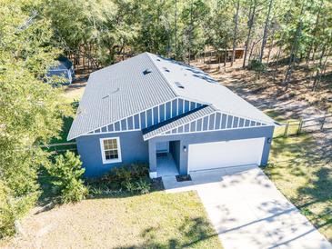 Aerial view of a charming one-story home with a two-car garage and spacious yard at 5919 Sw 124Th Terrace Rd, Ocala, FL 34481