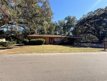 Ranch style home with carport and mature landscaping at 1705 Nw 17Th Ave, Ocala, FL 34475