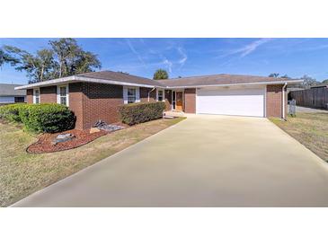 Brick ranch home with a two-car garage and well-manicured lawn at 3261 Se 32Nd St, Ocala, FL 34471