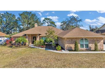 Brick house with brown roof, landscaping, and a spacious lawn at 407 Soft Shadow Ln, Debary, FL 32713