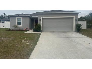 House exterior with gray siding and a two-car garage at 45 Orchid Ct, Kissimmee, FL 34759