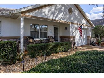 Charming home exterior with brick accents, a well-manicured lawn, and cozy front porch seating at 9691 Sw 95Th Ct # A, Ocala, FL 34481