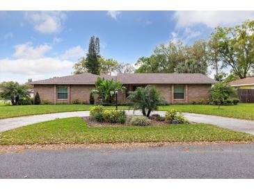 Charming brick home with circular drive and mature landscaping at 906 Crestview Dr, Auburndale, FL 33823