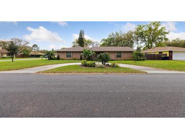 Charming single-story home with well-maintained landscaping and a circular driveway enhancing its curb appeal at 906 Crestview Dr, Auburndale, FL 33823