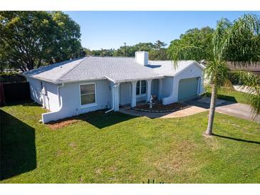 Charming single-story home with light blue exterior, well-maintained lawn, and welcoming front entrance at 8400 Mattituck Cir, Orlando, FL 32829