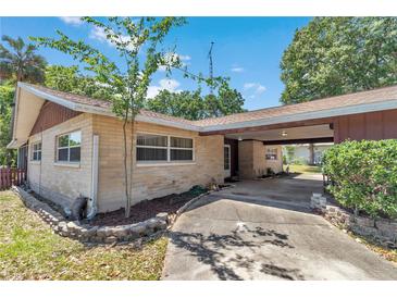 Charming brick home exterior featuring a covered carport and well-maintained landscaping at 8082 Sw 103Rd Ln, Ocala, FL 34481