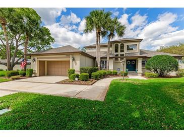 Charming two-story home with mature landscaping, lush green lawn, and an attached two-car garage at 1882 Royal Lytham Ct, Port Orange, FL 32128