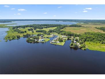 An aerial view showcases a beautiful lake community with homes nestled along the serene waterfront landscape at 3943 Nw 219Th Street Rd, Micanopy, FL 32667