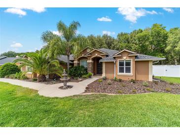 Charming home featuring a well-maintained lawn, decorative fountain, and lush landscaping at 5005 Se 47Th Terrace Rd, Ocala, FL 34480