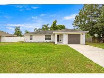 Cozy single-story home with an attached garage, front lawn, and simple landscaping at 680 Nw 67Th Pl, Ocala, FL 34475