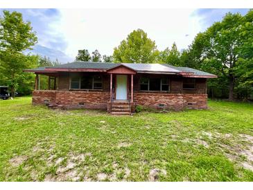 Quaint brick and wood home featuring a cozy front porch and a spacious yard at 3682 Jack Pine Ln, Ormond Beach, FL 32174