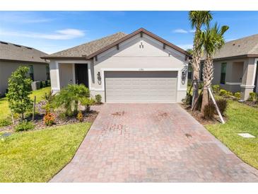 Charming single-story home featuring a two-car garage, well-maintained landscaping, and a brick driveway at 1192 Via Galuppi St, Kissimmee, FL 34759