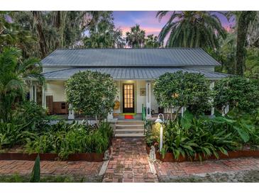 Charming home featuring mature landscaping, brick path, and a welcoming front porch at 5881 Avenue H, Mc Intosh, FL 32664