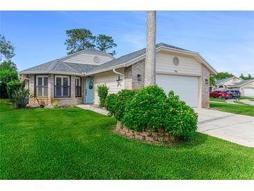 Charming single-story home with well-manicured lawn, brick accents, and a light blue front door at 916 Ashmeade Ct, Port Orange, FL 32127