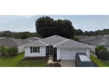 Charming single-story home featuring a well-maintained lawn and an attached one car garage at 32932 Crooked Oaks Ln, Leesburg, FL 34748