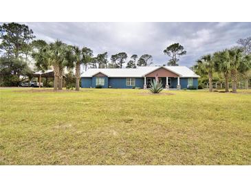 Single story home with blue exterior, metal roof and large yard at 112 Reedy Creek Dr, Frostproof, FL 33843