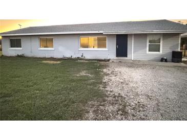 Newly painted light gray house with a blue door, and a grassy yard at 2000 Mcclellan Rd, Frostproof, FL 33843