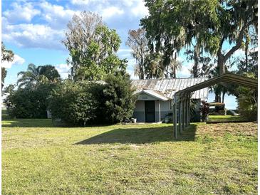 Charming single-story home featuring a metal roof and a convenient carport at 1385 N Lake Reedy Blvd, Frostproof, FL 33843