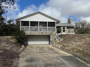 Charming home featuring stone accents, screened porch, and a convenient attached garage at 2134 R E Byrd Rd, Frostproof, FL 33843