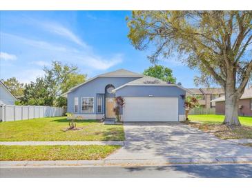 Charming single-Gathering home featuring a well-maintained lawn, attached two-car garage and a lovely blue exterior at 2616 Huntington Ct, Kissimmee, FL 34743