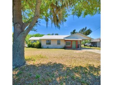 Exterior front view of a single-story home with a metal roof, covered entry, and mature tree in the front yard at 352 E Hwy 630 E, Frostproof, FL 33843