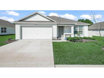 Charming single-story home with a well-manicured lawn and attached two-car garage on a sunny day at 4833 Drake Ave, Lakeland, FL 33811