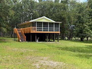 Charming home featuring a screened porch, elevated design, and a tranquil wooded setting at 1885 Pfundstein Rd, Babson Park, FL 33827