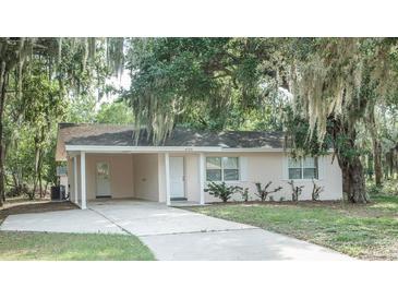 Charming single-story home featuring a covered parking area and mature trees draped with Spanish moss at 4725 Kayworth Rd, Lake Wales, FL 33898
