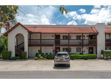 A cozy condo showcases a red tile roof and a charming, well-maintained facade with ample parking at 6201 Country Club Dr # 21, Lake Wales, FL 33898