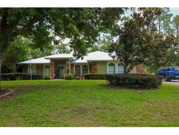 Charming ranch-style home with a lush green lawn and mature trees, offering a serene and inviting curb appeal at 9365 Lemon Dr, Lake Wales, FL 33898