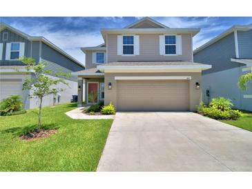 Charming two-story home with a well-manicured lawn, large driveway, and an inviting red door at 1417 Leamington Ln, Winter Haven, FL 33884