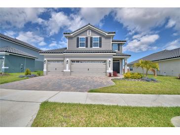 Stunning two-story home featuring a three-car garage and lush landscaping at 4646 Grandview Glen Dr, Auburndale, FL 33823