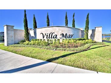 Elegant Villa Mar community entrance sign with lush landscaping and bright blue sky at 1484 Leamington Ln, Winter Haven, FL 33884