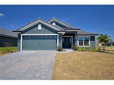 Beautiful one story home featuring a two car garage, tiled roof and well manicured lawn at 4938 Vue Delac Pass, Auburndale, FL 33823