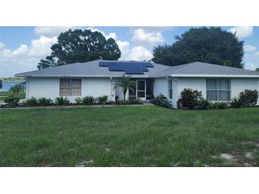 Charming single-story home featuring a white brick exterior, solar panels, well-maintained landscaping and inviting front porch at 152 Audubon Ct, Winter Haven, FL 33884